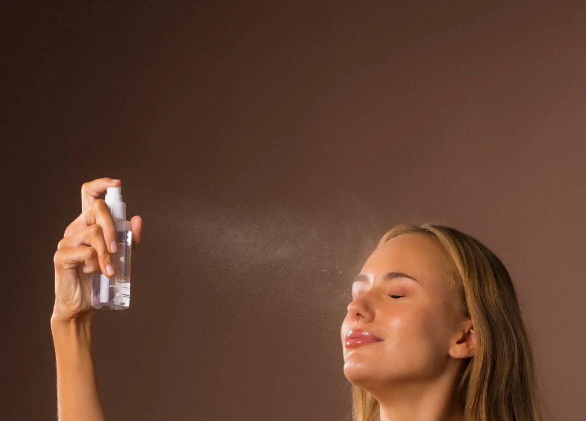 Modèle vaporisant la brume autobronzante Hydraglow sur son visage
